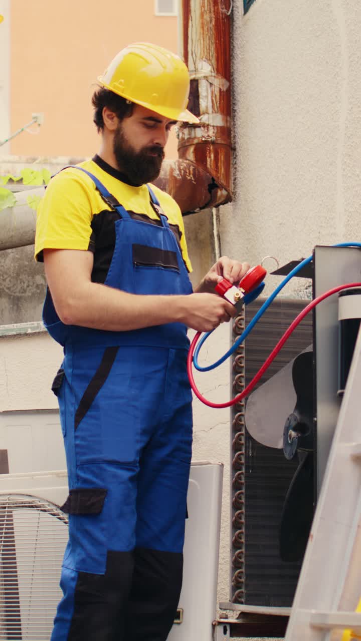 Vertical video Mechanic and colleague fix condenser