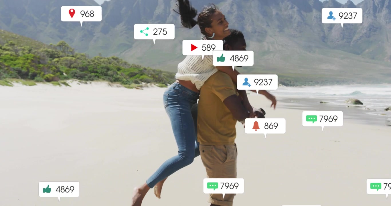 Couple sharing beach with woman leaping piggyback and man carrying amid social media icons rising