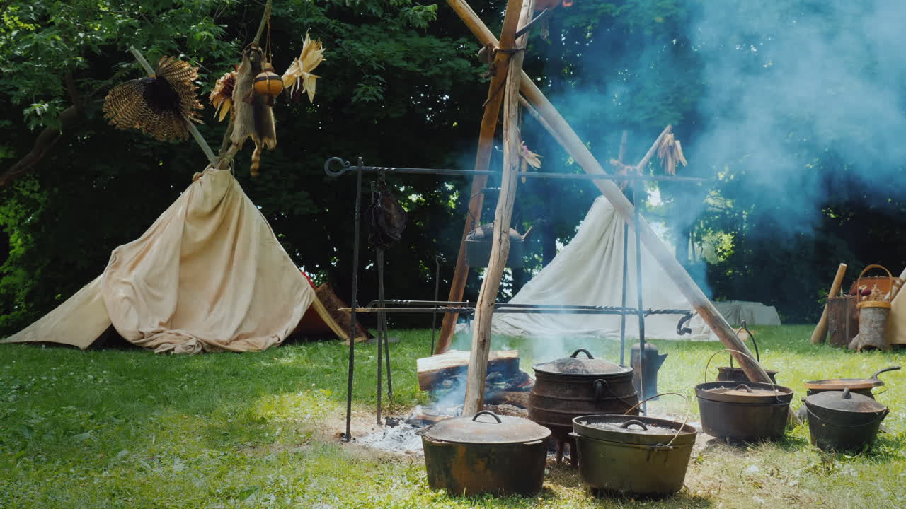 숲 음식에 있는 아메리카 원주민 캠프가 전경 전통 wigwam 텐트에서 준비되고 있습니다.
