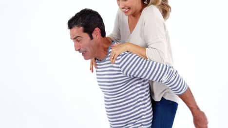 hombre feliz dando una bolsa de cerdo a una mujer contra un fondo blanco