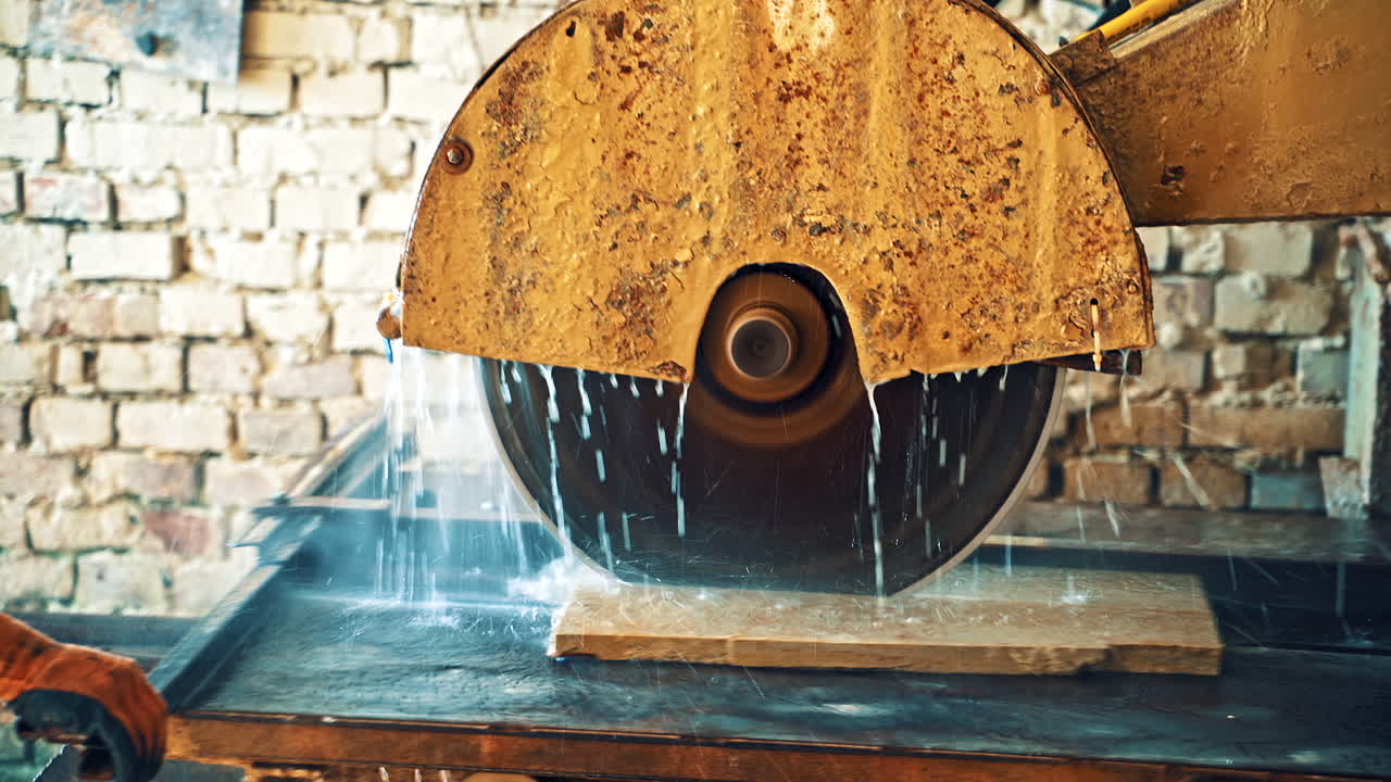 Circle wheel of electric machine for cutting stone slab. CNC manufactoring machine of sawing stone. Process of cutting slab with water. Close-up.