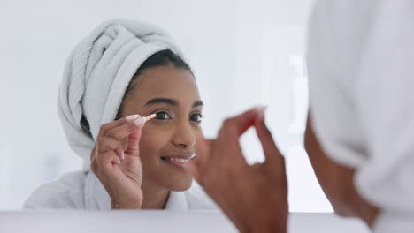 Woman,-tweezers-and-eyebrows-in-mirror