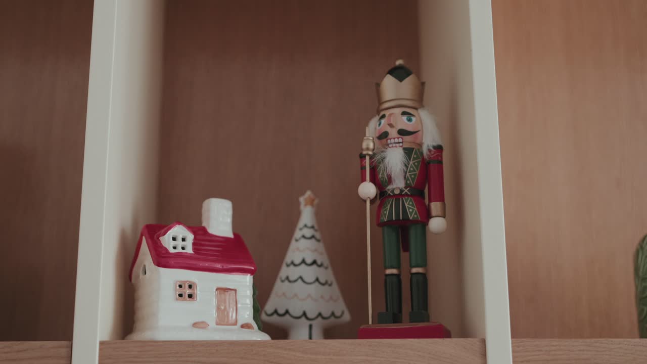 Nutcracker figurine with small house and tree decoration on shelf