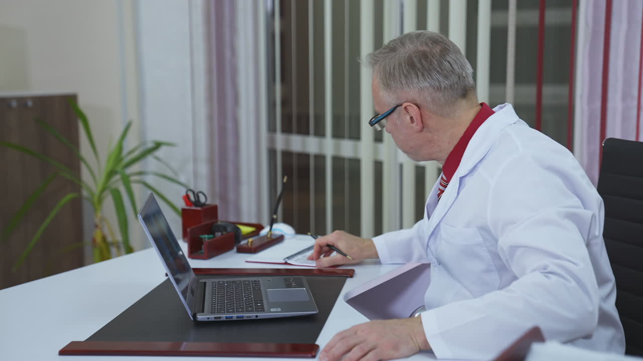 Video call consultation. Male doctor using tablet video call speaks with patient
