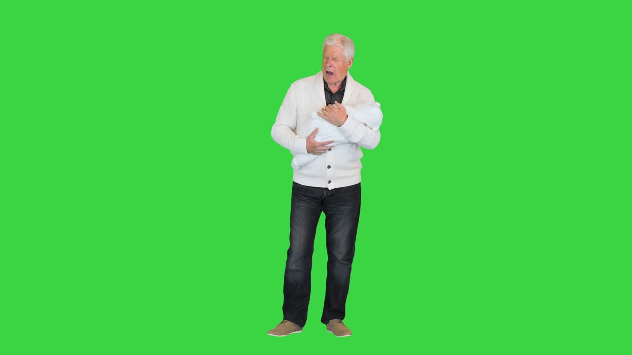 Sleepy and tired grandfather holding toddler on a Green Screen, Chroma Key