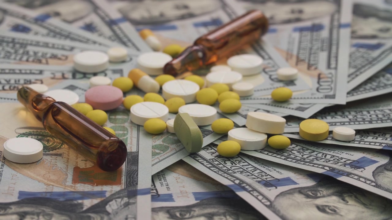 Spese mediche: varie pillole e fiale su banconote da dollari USA