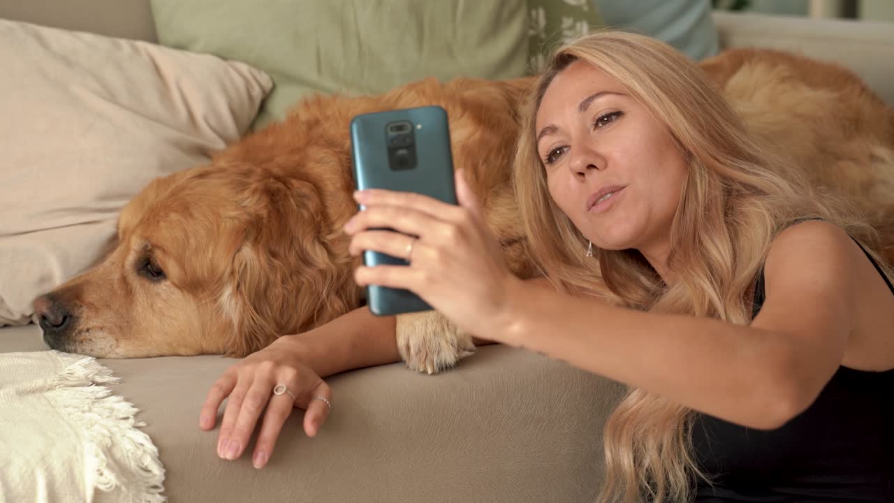 Happy student pet owner doing selfie picture, talking and laughing with Labrador