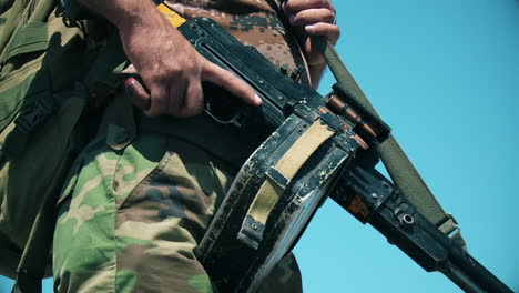 An-army-soldier-holds-a-gun-in-his-hand