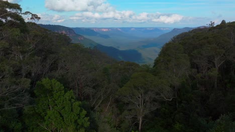 blue mountains aerial drone katoomba sydney nsw australia sunny bluesky clouds three sisters echo point lookout cliff walk national park gum tree eucalyptus forest arvo afternoon forward pan up motion