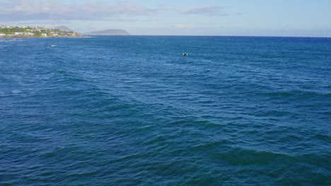 Imágenes-De-Drones-Sobre-Las-Olas-Azul-Real-Del-Océano-Pacífico-Mientras-Surfistas-Y-Practicantes-De-Kitesurf-Aprovechan-El-Viento-Para-Deslizarse-Sobre-El-Agua.