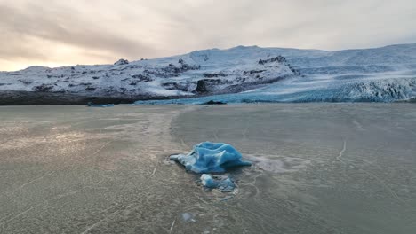 vista aérea del paisaje sobre un iceberg cerca de un glaciar que se derrite con formaciones de hielo, en islandia, al atardecer