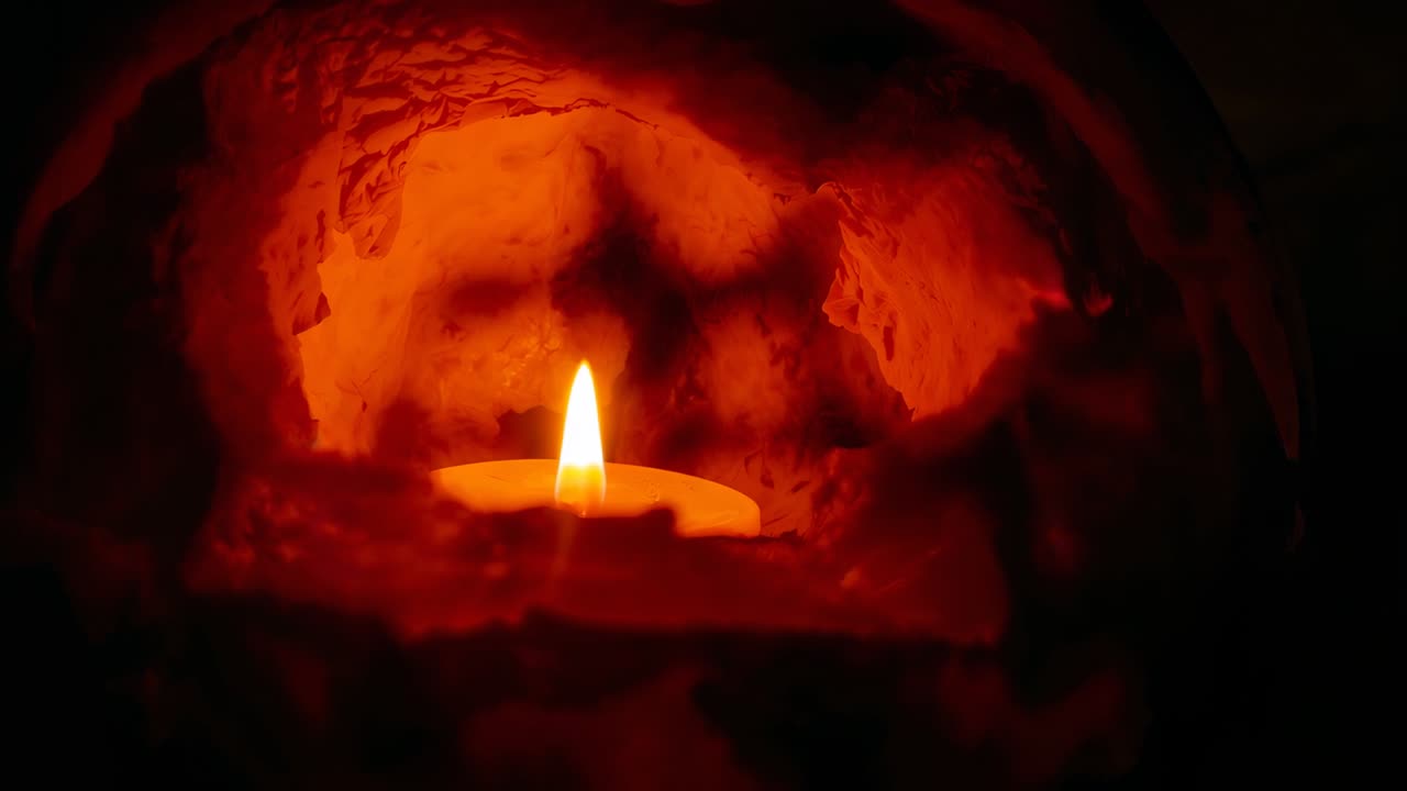 Igniting small tealight candle lighting stone alcove for warm glow, with flickering shadows dancing
