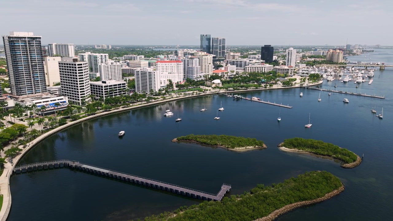 Ripresa aerea: grattacieli del centro di West Palm Beach con isolotti e palme di giorno in Florida, USA, scatto con drone orbitale