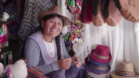 medium shot of traditional woman (cholita) weaving in the recoleta market, sucre