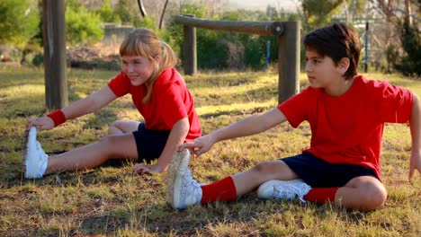 Niños-Realizando-Ejercicios-De-Estiramiento-En-El-Campo-De-Entrenamiento.