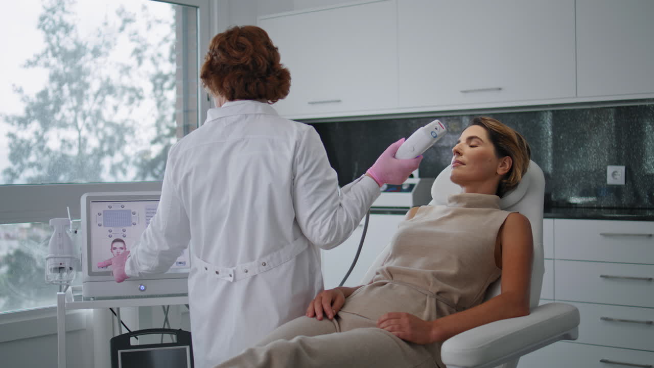 médico que ajusta el equipo de cosmetología al tratamiento por ultrasonido en la clínica.