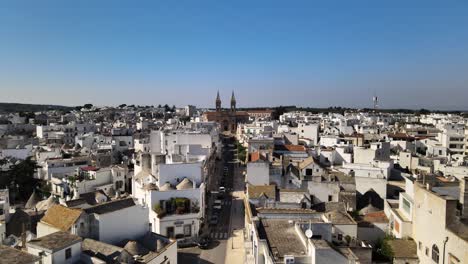 tiro aéreo de drones volando a una catedral en alberobello, italia