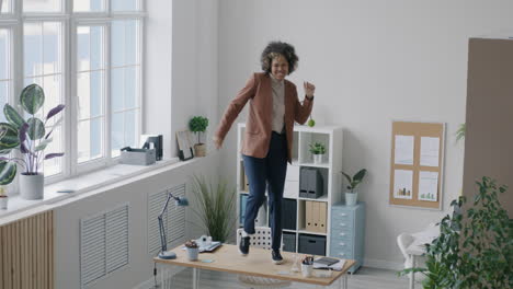 woman dancing on a desk in a modern office