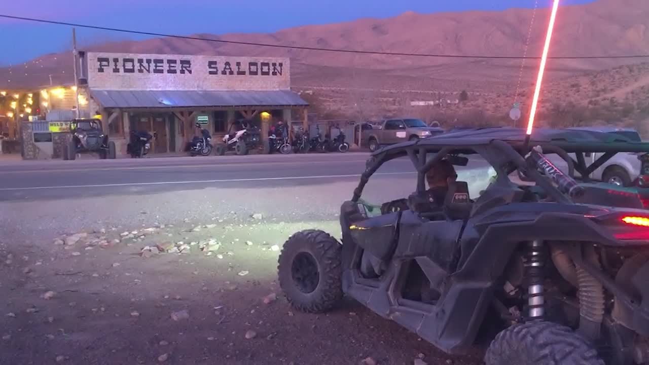 Off-road vehicles parked outside the historic Pioneer Saloon at dusk