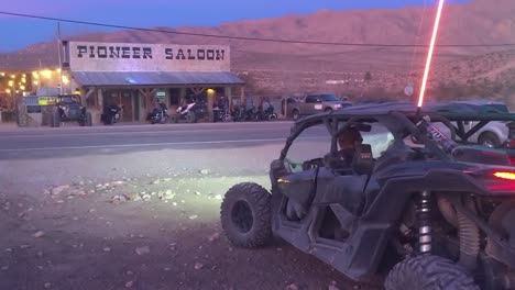 off-road vehicles parked outside the historic pioneer saloon at dusk