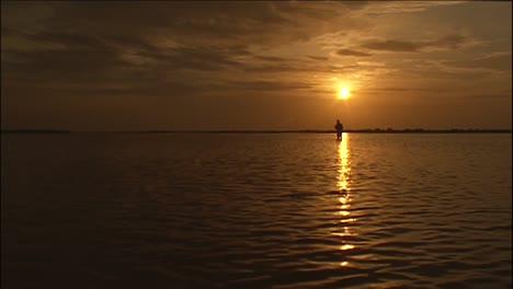 A-Fly-Fisherman-Stands-In-A-Río-At-Sunset-In-This-Beautiful-Shot