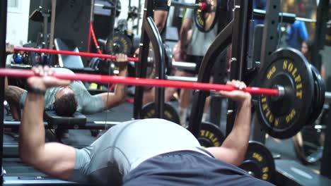 a muscular bodybuilder, passionately working out at the gym, lifts weights working on his chess