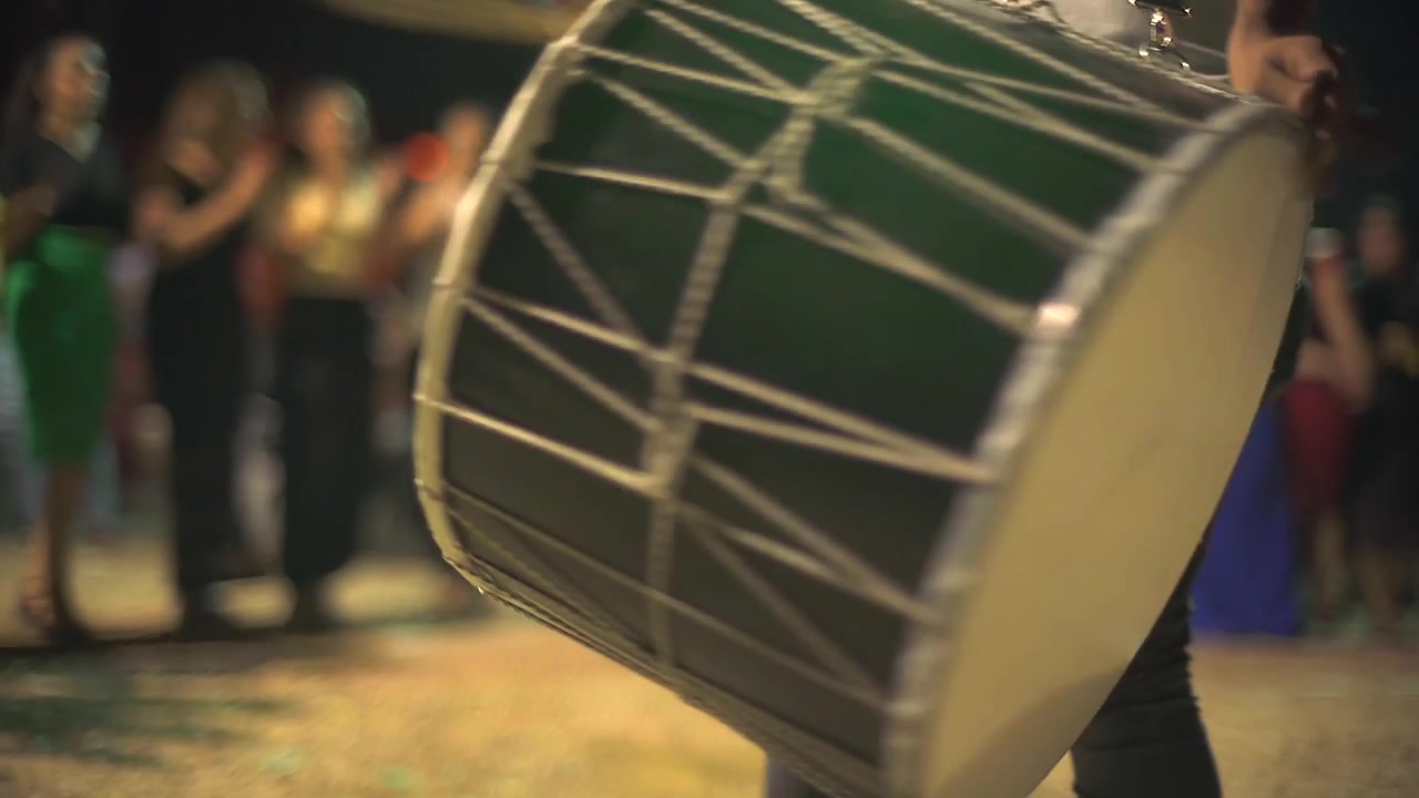 Musician Playing Traditional Davul Drum at Nighttime Outdoor Celebration