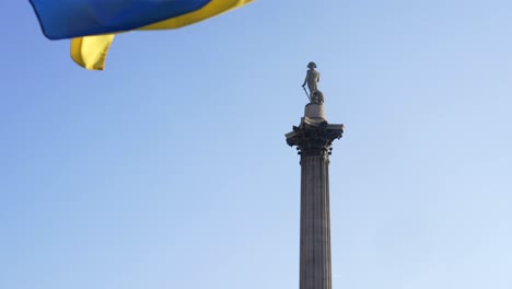 london stands with ukraine, ukrainian flag waving in trafalgar square in london during protest against war with russia