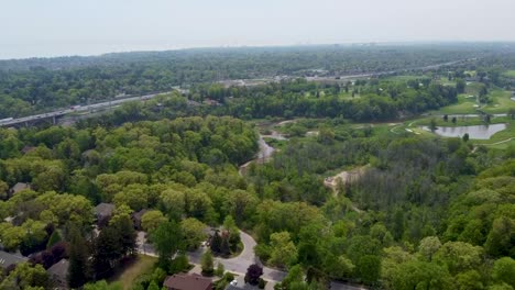 Volando-Sobre-Espacios-Verdes-En-Mississauga-Con-Un-Campo-De-Golf-Y-El-Qew-En-El-Fondo