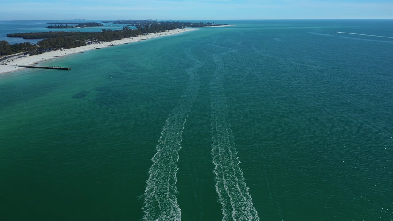 Wake trails create patterns in the emerald waters off Bradenton Beach. Ideal for coastal and maritime themes.