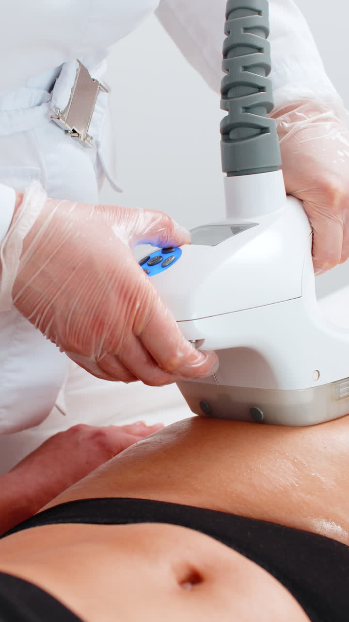 Un medico esegue un massaggio cavitazionale LPG con rullo vacuum su una donna per la correzione delle gambe in una clinica spa