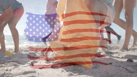 animación de la bandera de los ee.uu. sobre felices amigos diversos reciclando en la playa en verano