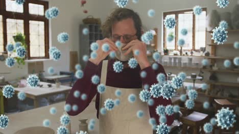 Animación-De-Células-Virales-Sobre-Un-Hombre-Caucásico-Con-Mascarilla-En-El-Taller