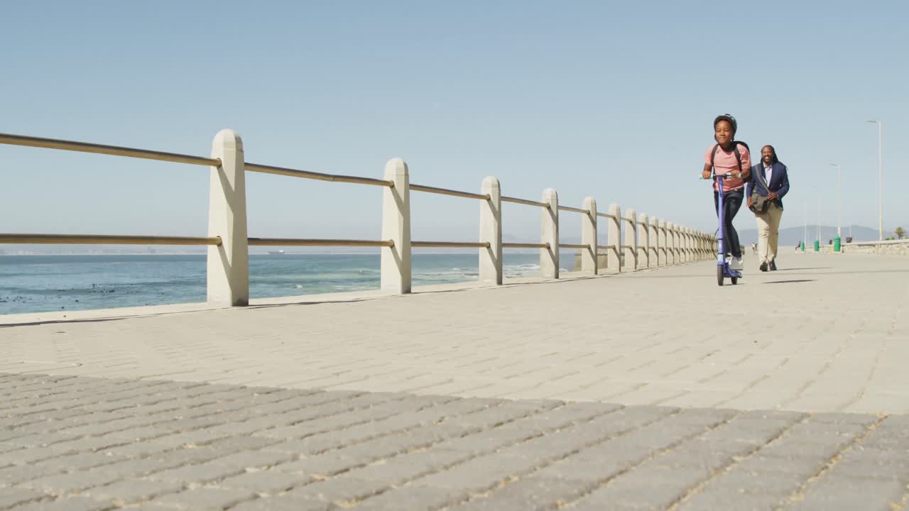 스쿠터를 타고 해변에서 시간을 보내는 행복한 아프리카계 미국인 아버지와 아들의 비디오