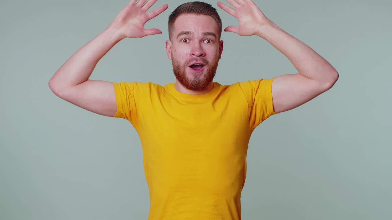 놀라서 흥분한 남자가 커다란 눈으로 카메라를 쳐다보며 놀랐습니다. 갑작스러운 승리에 충격을 받았습니다.