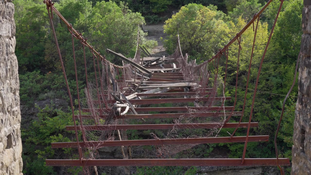 Broken footbridge crossing wild Vjosa Aoos River Përmet region Albania mountain valley