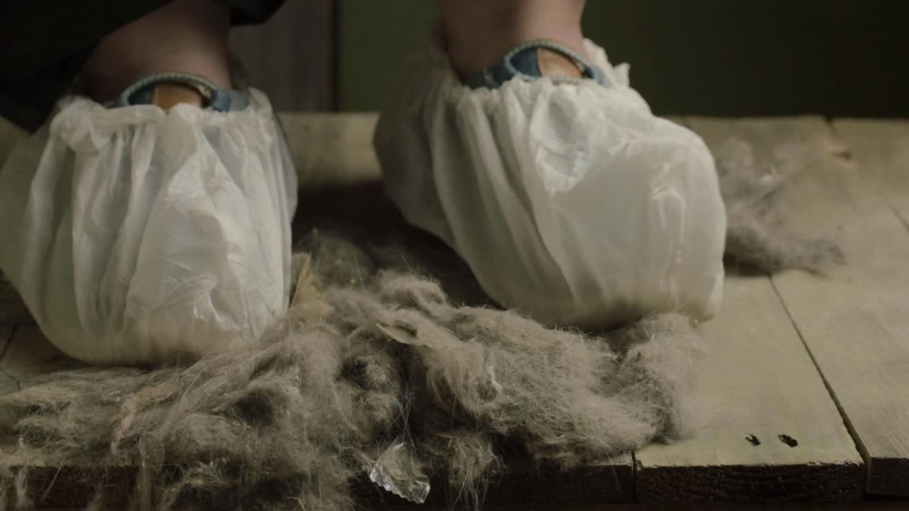 un par de pies con protectores de zapatos desechables en un ambiente polvoriento y sucio