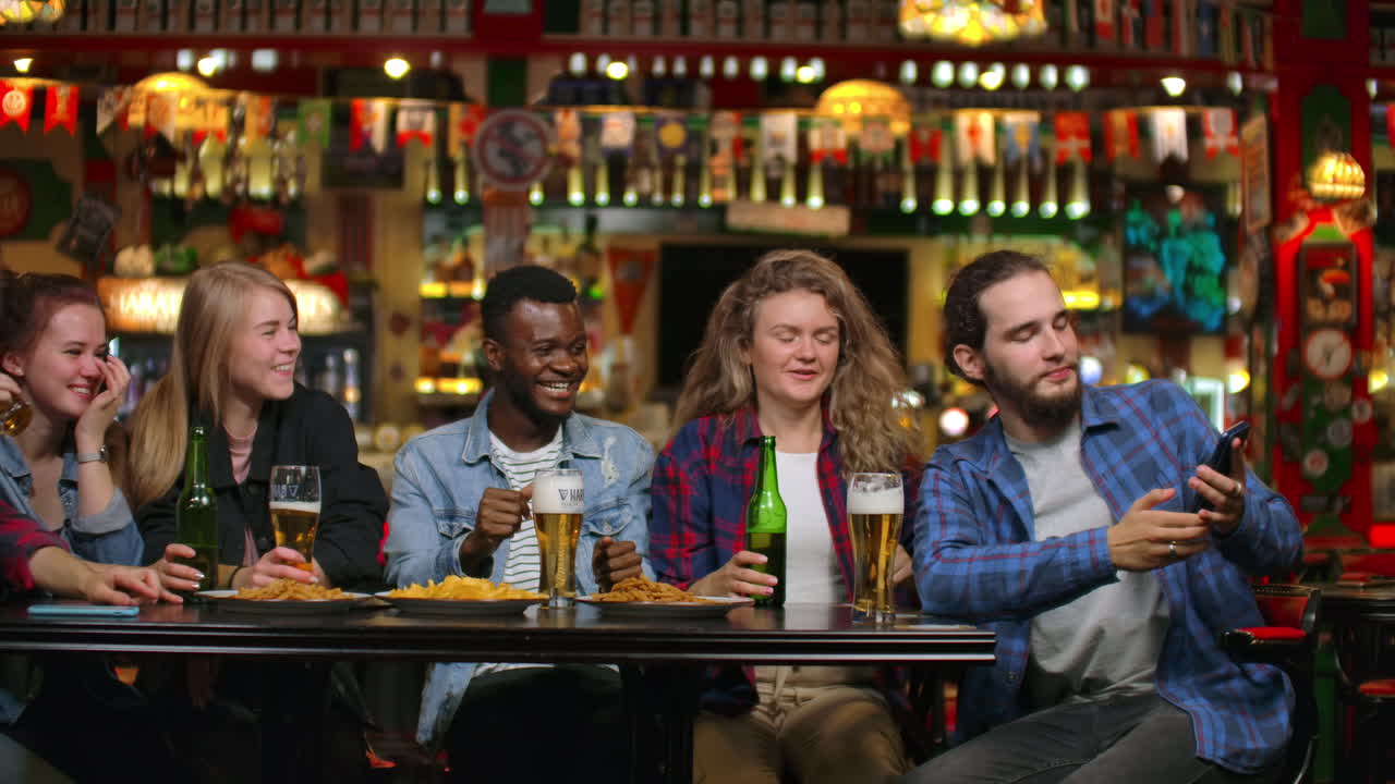 친구들은 술집에서 전화로 사진을 찍고, 술집에서는 맥주와 함께 친구들과 파티를 합니다.