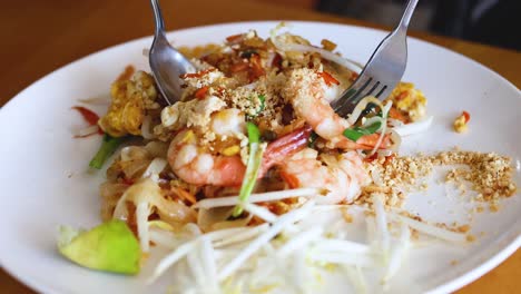 el delicioso pad thai está siendo preparado y servido.