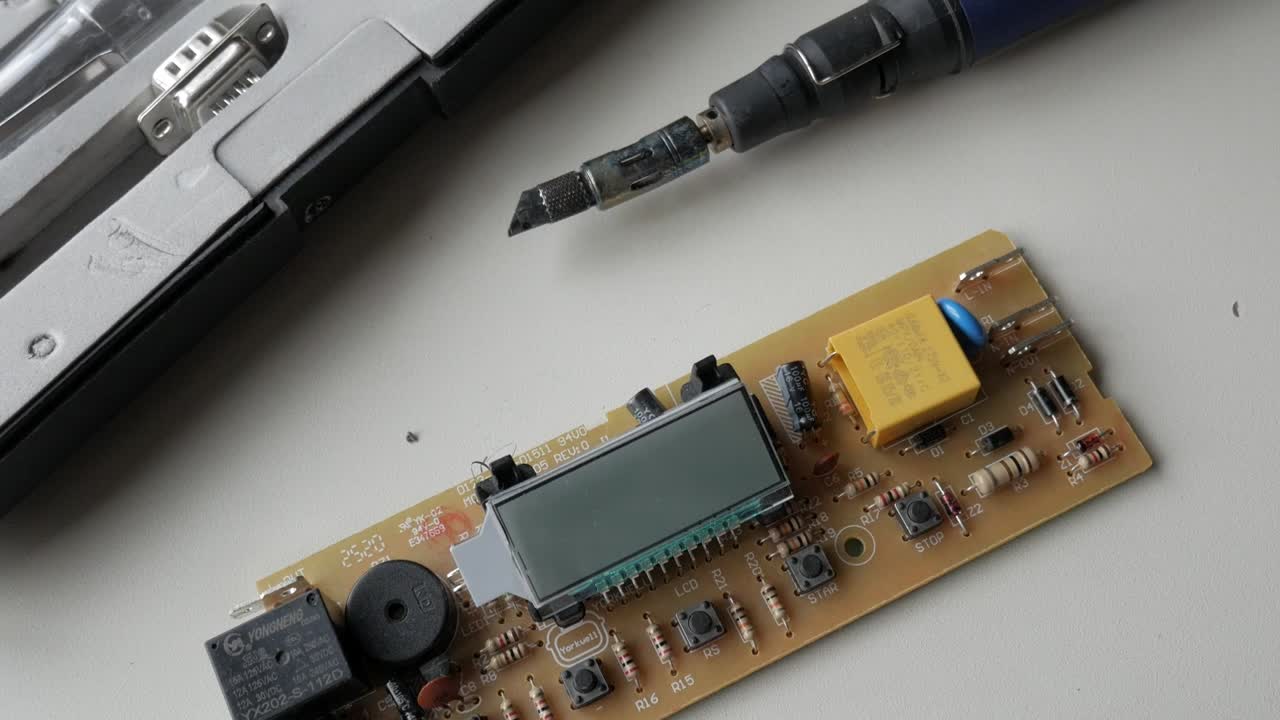 Close-up of an electronic circuit board with components and soldering tools