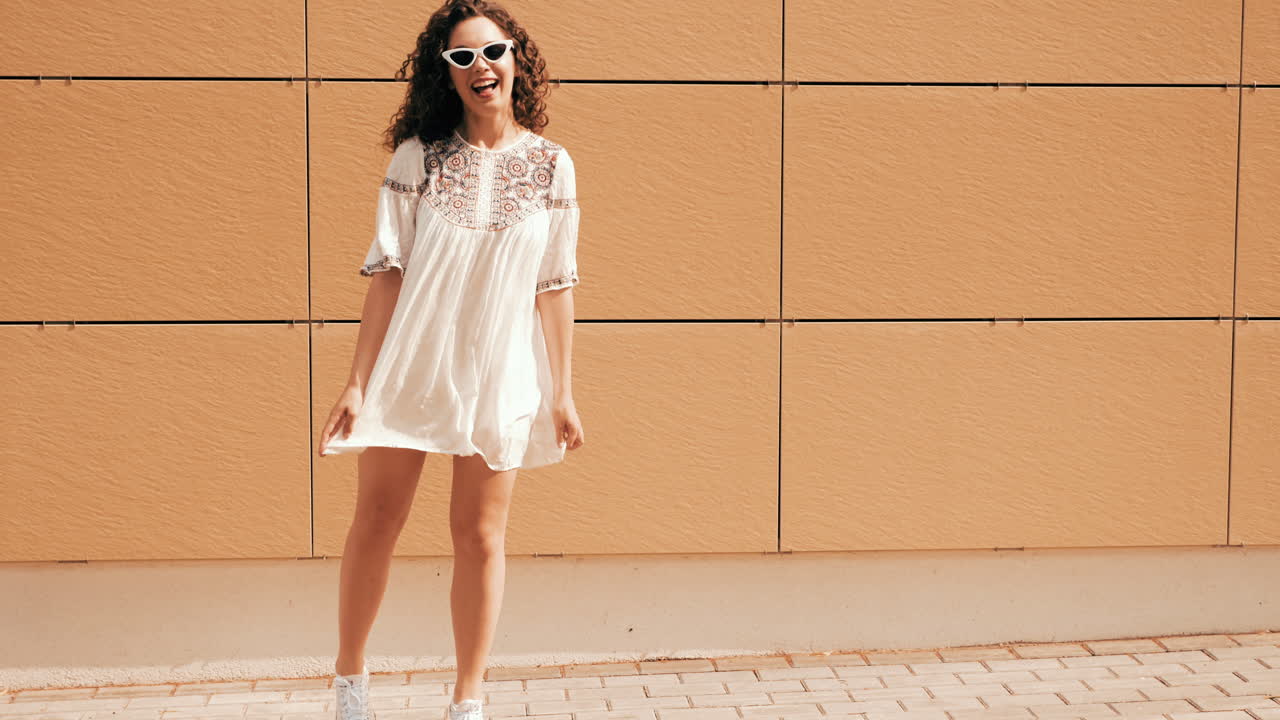 하 드레스를 입은 젊은 여성이 야외를 즐기고 있습니다.