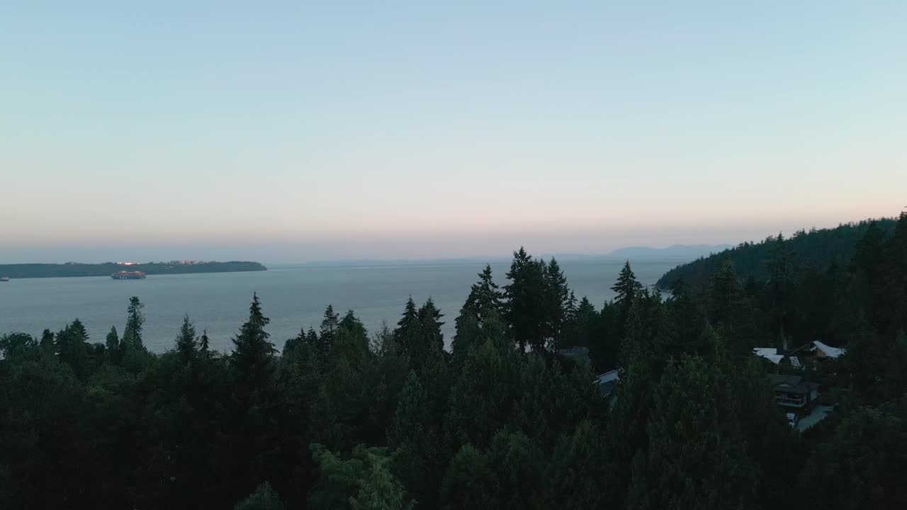 Et smukt luftfoto af en solnedgang over West Vancouver, Canada med træer i forgrunden