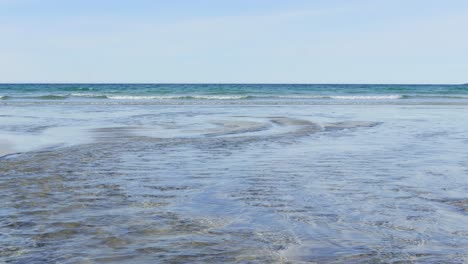 The-creek-meets-the-sea-on-the-beach-in-a-sunny-day