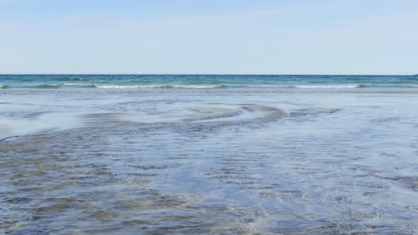 the creek meets the sea on the beach in a sunny day