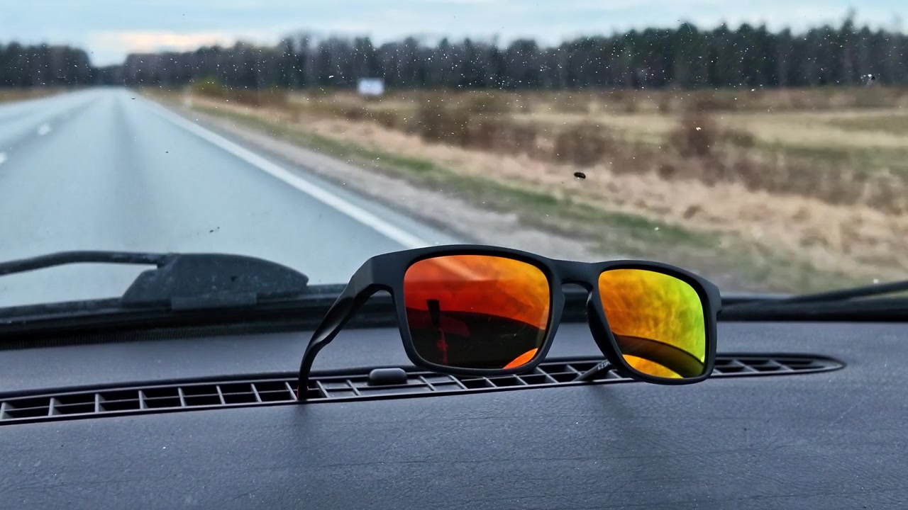 POV footage of driving on a countryside road with sunglasses on the car dashboard
