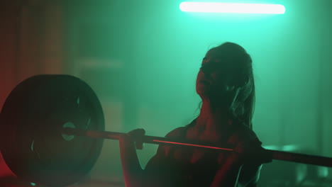 female powerlifter is working hard in gym woman is lifting barbell and throwing down