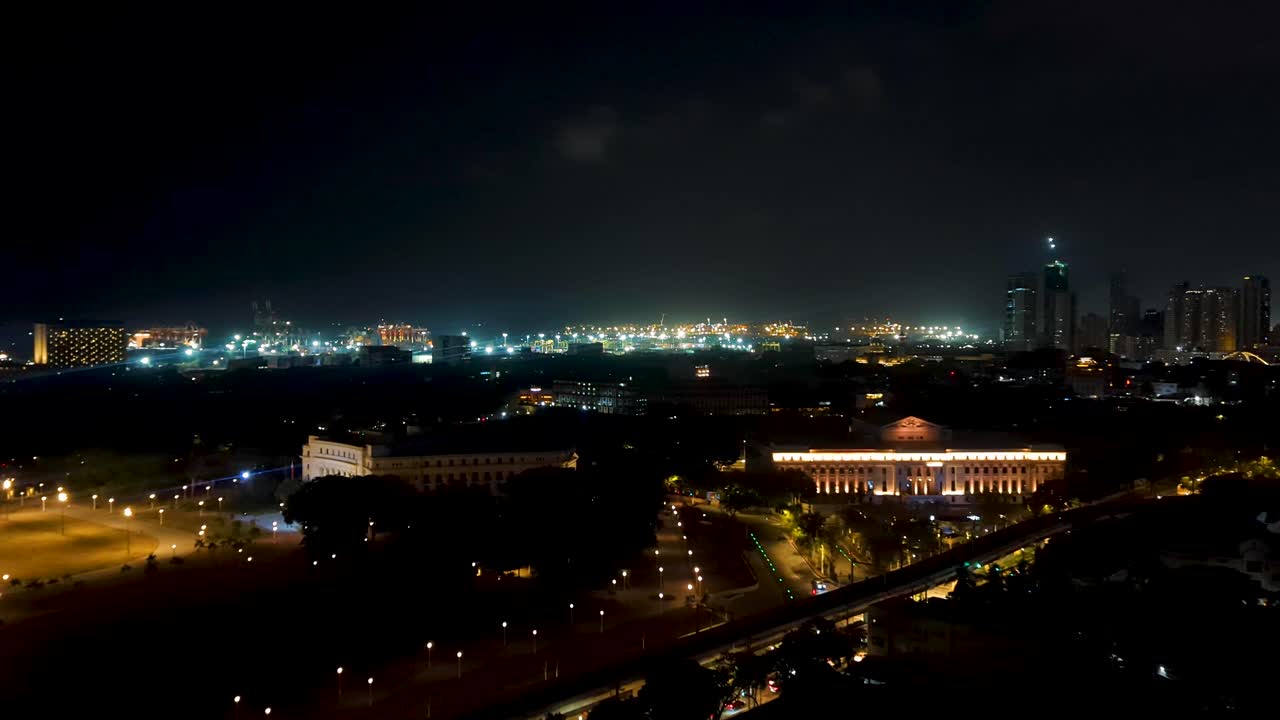 Aerial view of capital city of Manila Philippines at night during thunder and lightning storm with lit up skyline