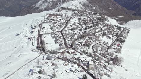 Bird's-eye-view-establishing-over-the-mountain-village-of-Farellones-after-a-winter-snowfall,-Chile