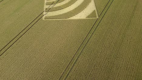 Flyover-aerial-view-passing-repeating-wave-crop-square-in-Micheldever-2023-wheat-field,-Hampshire