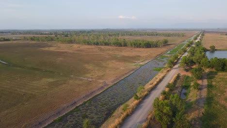 Luftaufnahmen,-Die-Eine-Landstraße-Und-Einen-Kleinen-Wald-In-Der-Ferne-Zeigen,-Pak-Pli,-Nakorn-Nayok,-Thailand